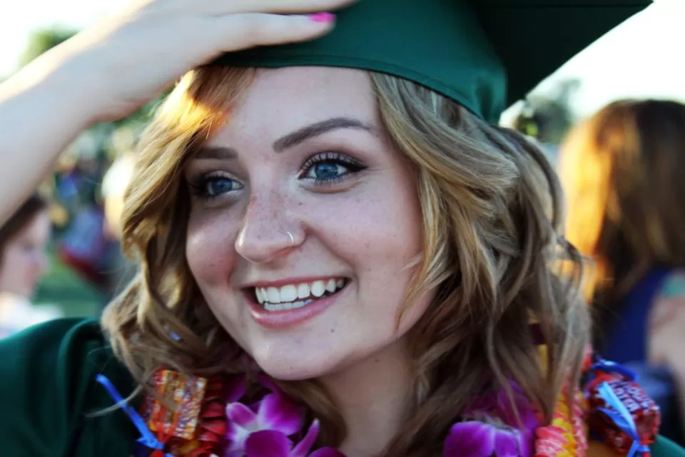 A smiling graduate in cap and gown