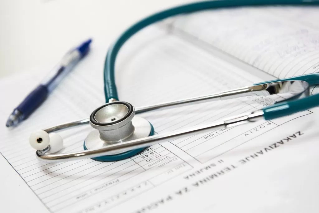 A stethoscope and pen resting on a medical form