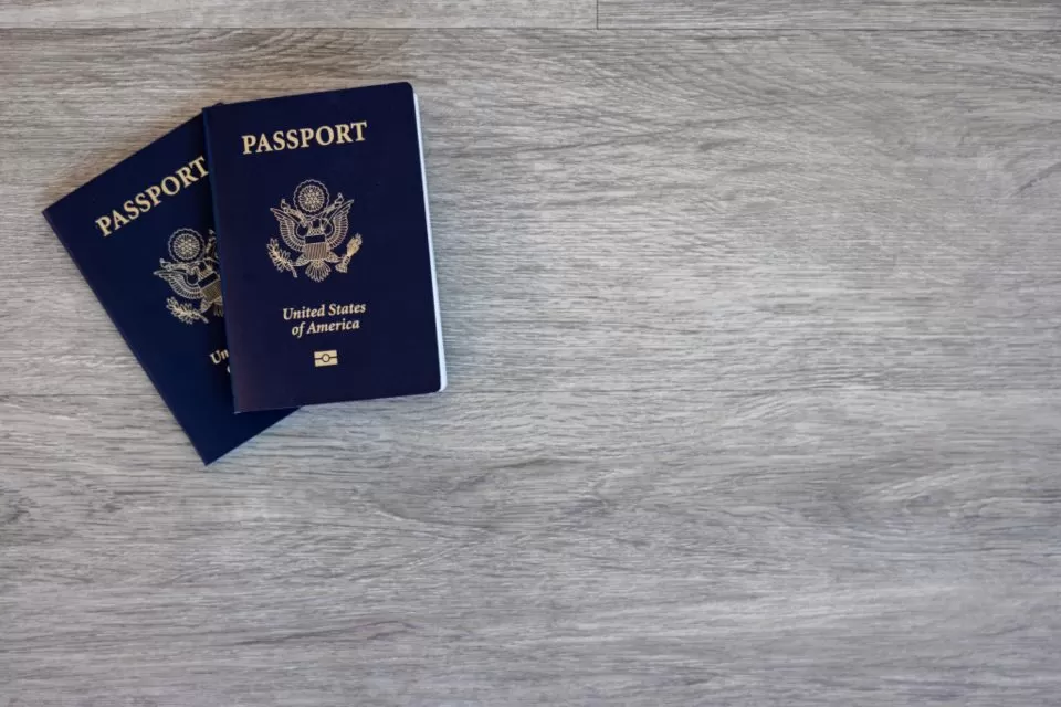 Two United States passports on a wooden desk